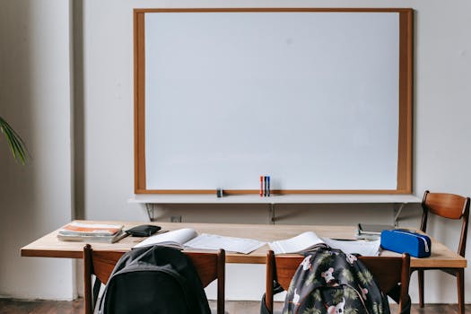 pexels photo 5905441 5905441 Empty classroom with wooden desks, chairs, and a large whiteboard. Ideal for educational themes.